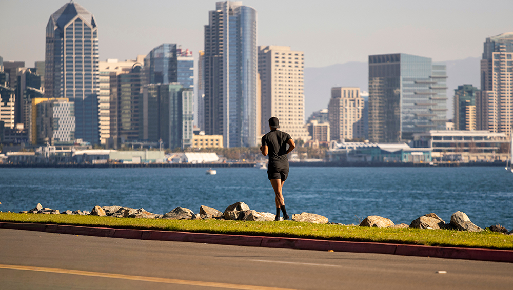 Active runner along the San Diego coast with the downtown skyline behind